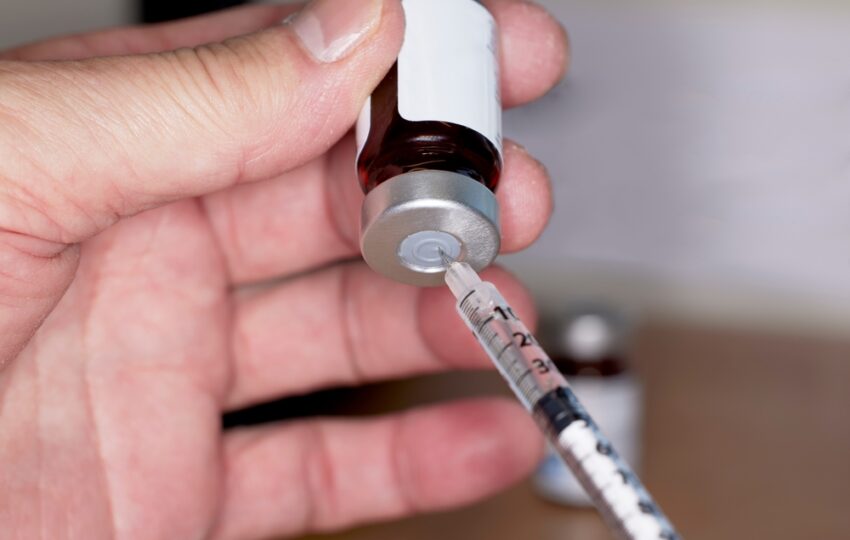 Hand drawing testosterone injection from vial showing how long TRT takes to work for men in Oswego IL