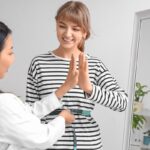 Healthcare provider measuring patient waist celebrating medical weight loss results at a wellness clinic