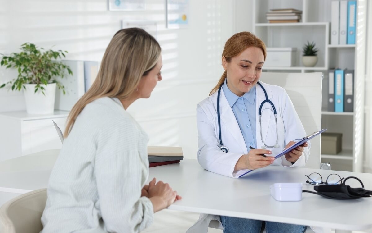 Female provider explaining how long does HRT take to work to a patient in a clinic