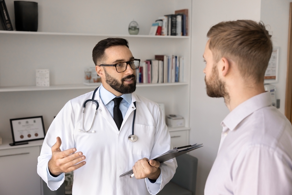 Male provider discussing low testosterone and weight gain with a patient in a clinic