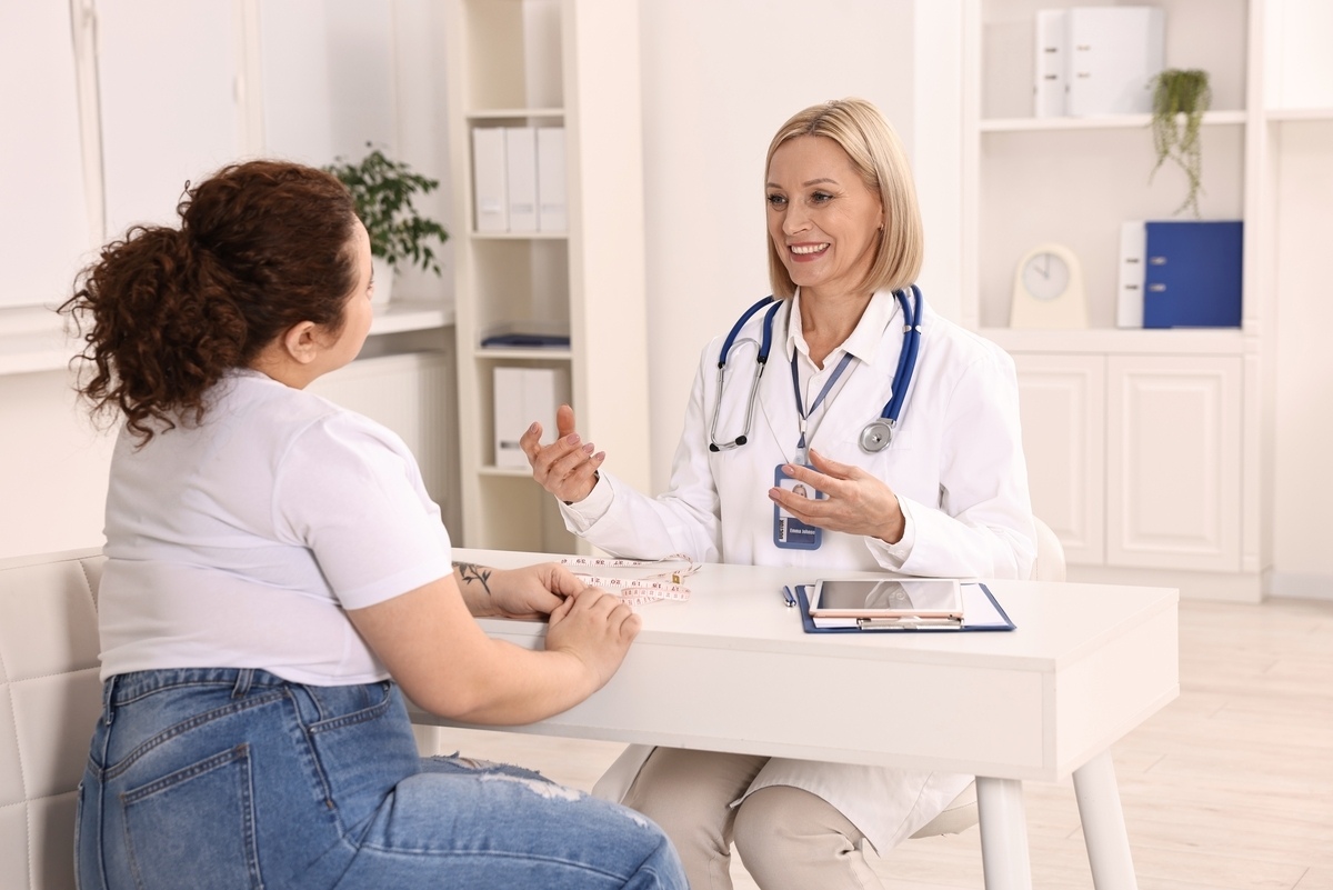 Healthcare provider explaining a medical weight loss consultation to a female patient in a modern clinic