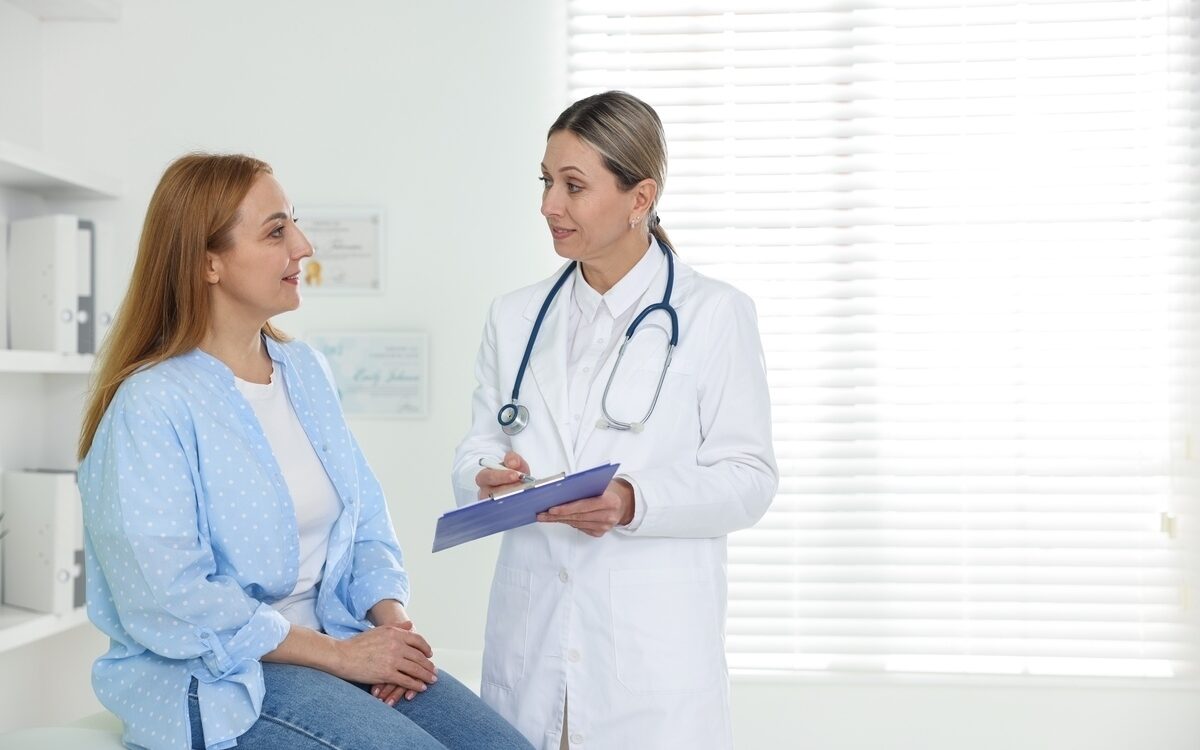 Female doctor taking notes during an HRT and weight loss consultation with a woman at a medical clinic