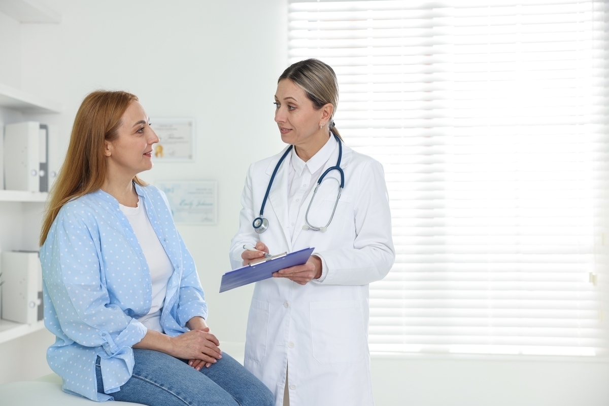 Female doctor taking notes during an HRT and weight loss consultation with a woman at a medical clinic