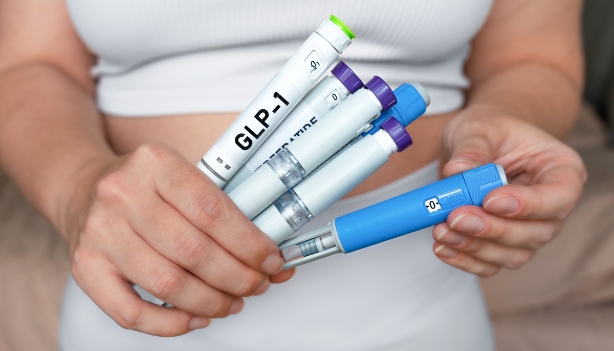 Person holding GLP-1 injection pens comparing semaglutide vs tirzepatide weight loss medication options side by side