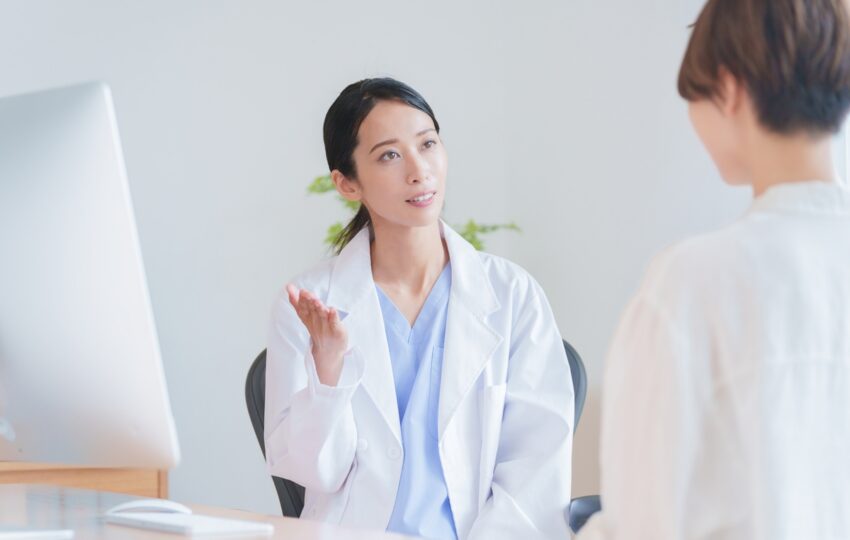 Female healthcare provider explaining bioidentical vs synthetic HRT options to a patient during a clinical consultation