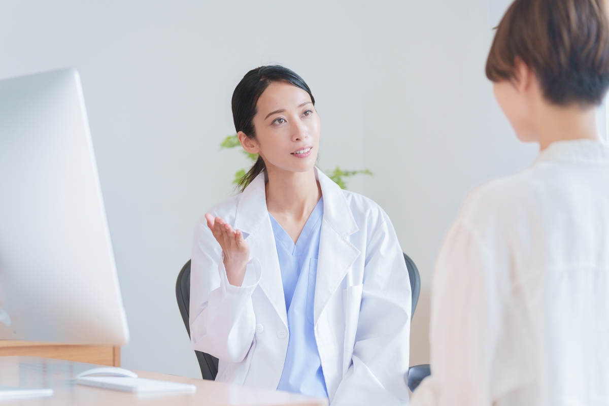Female healthcare provider explaining bioidentical vs synthetic HRT options to a patient during a clinical consultation