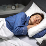 A woman in her 40s sleeping peacefully representing improved sleep quality through HRT for sleep in women during perimenopause and menopause