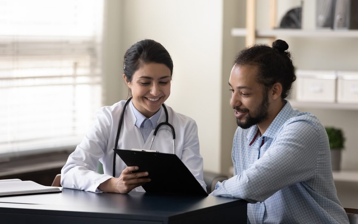Female healthcare provider reviewing insulin resistance and weight loss evaluation results with a male patient during a clinical consultation