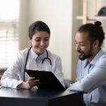 Female healthcare provider reviewing insulin resistance and weight loss evaluation results with a male patient during a clinical consultation