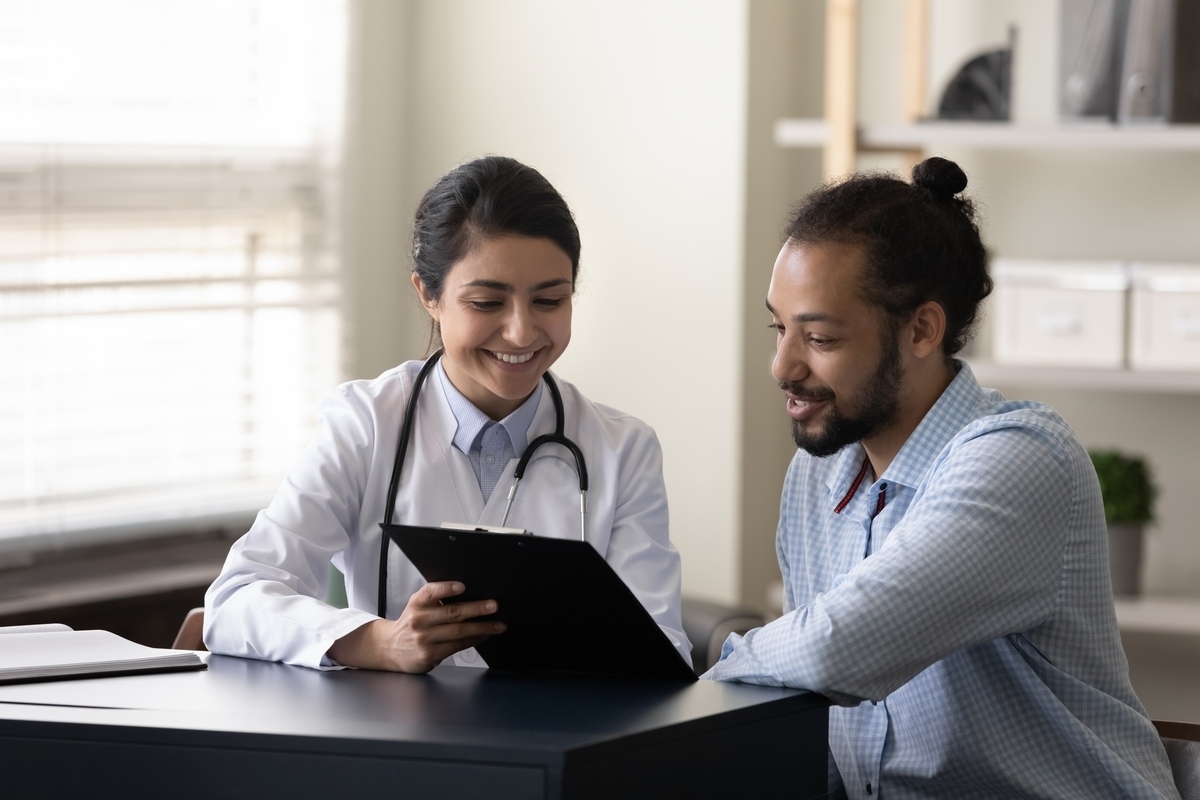 Female healthcare provider reviewing insulin resistance and weight loss evaluation results with a male patient during a clinical consultation