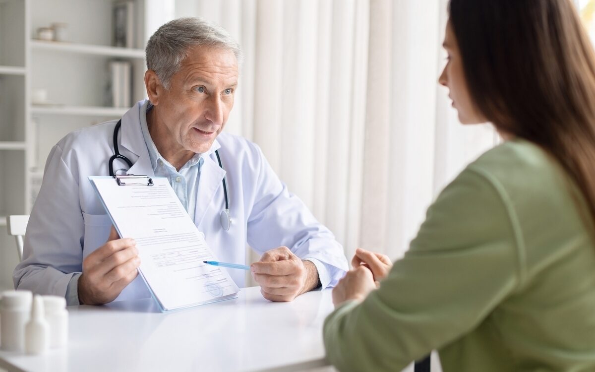 Healthcare provider explaining insurance coverage for weight loss treatment to a patient while reviewing documentation during a clinical consultation