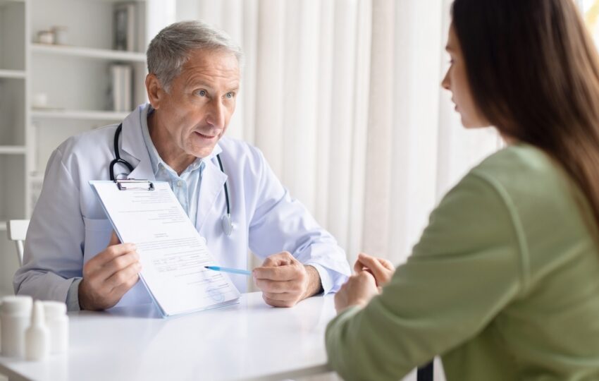 Healthcare provider explaining insurance coverage for weight loss treatment to a patient while reviewing documentation during a clinical consultation