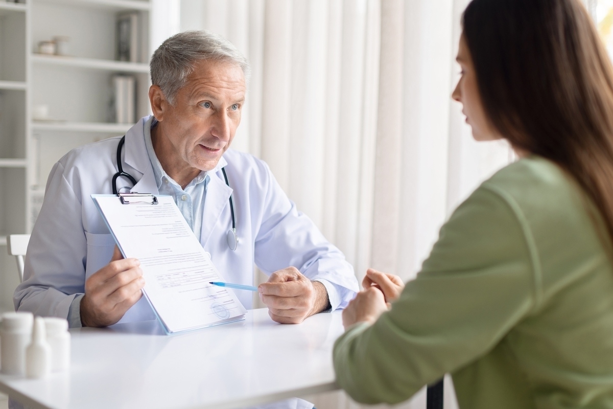 Healthcare provider explaining insurance coverage for weight loss treatment to a patient while reviewing documentation during a clinical consultation